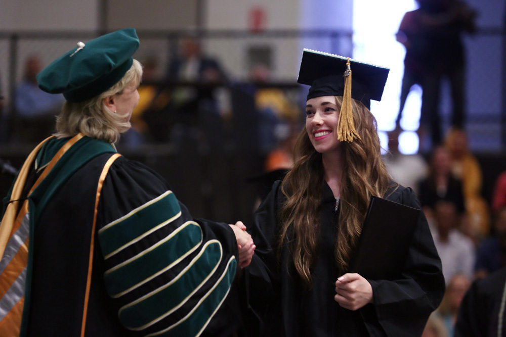 Tilden shakes S&T Chancellor Cheryl Schrader's hand as she crosses the stage at commencement in May 2015. 